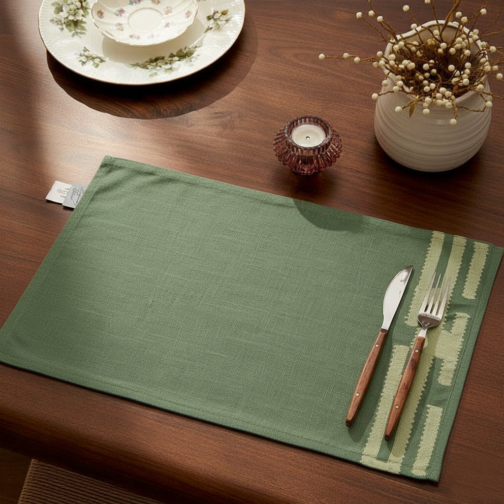 Jade green chambray placemat with soft stitched beige detail, minimalist design